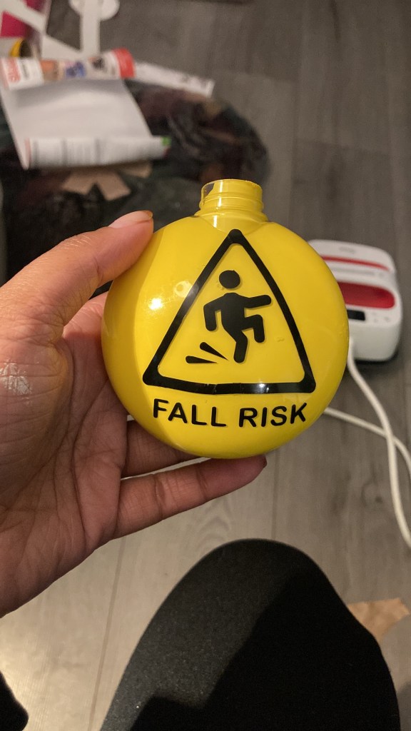 a yellow Christmas ornament with a black triangle and a falling person icon, and the text "Fall Risk" under it.
